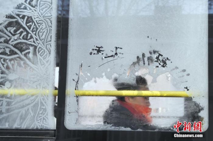 资料图：辽宁沈阳，一位女乘客坐在凝结出冰花的车窗旁，当日是大寒节气。<a target='_blank' href='/'><p align=